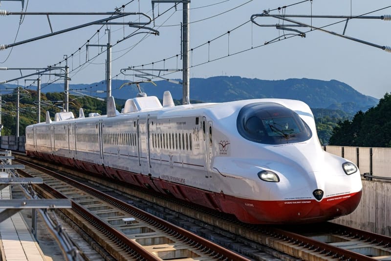 The Nishi Kyushu Shinkansen "Kamome" train, a sleek white high-speed train with a red lower accent, traveling on the tracks.